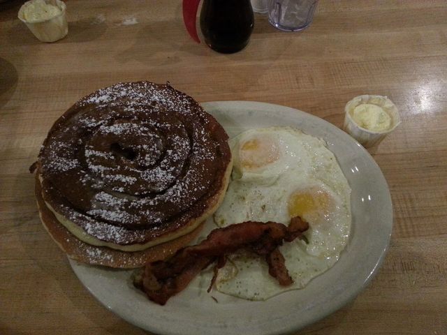 A diner breakfast plate of pancakes, bacon, and eggs