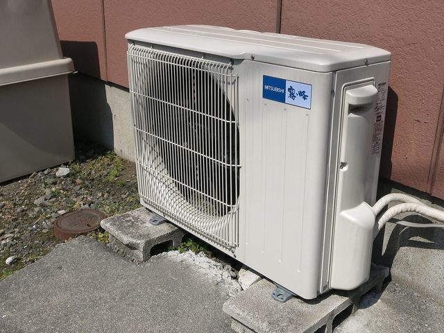 An outdoor air conditioning unit beside a home