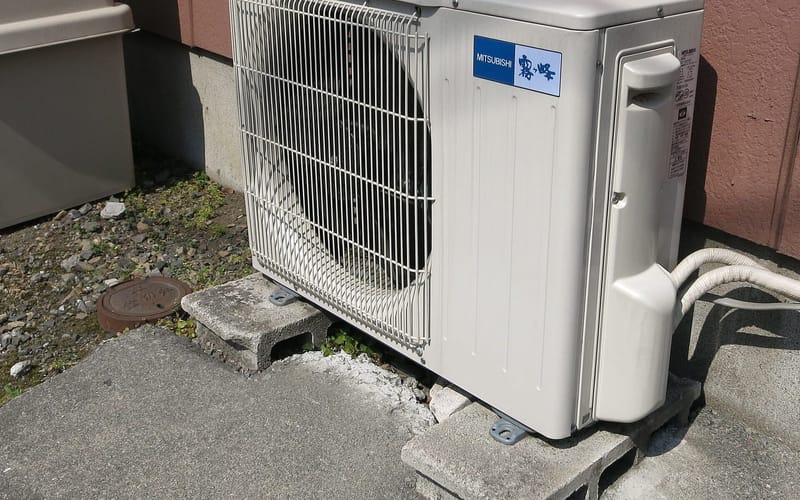 An outdoor air conditioning unit beside a home