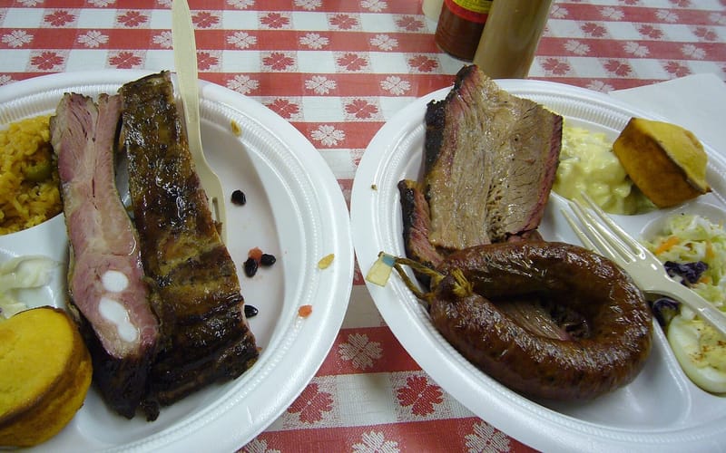 Plates of brisket, pork ribs, and sausage