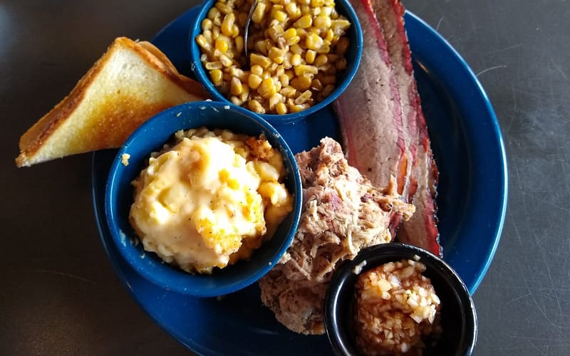 A barbecue tray with pulled pork, brisket, and sides