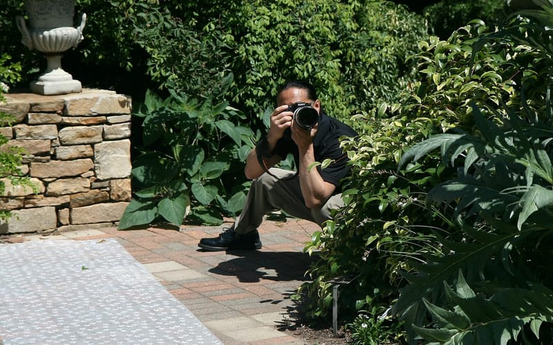 A wedding photographer shooting an outdoor ceremony