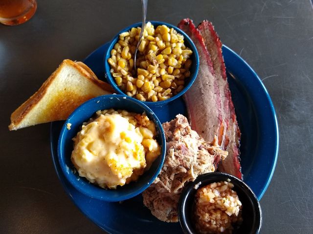 A barbecue tray with pulled pork, brisket, and sides