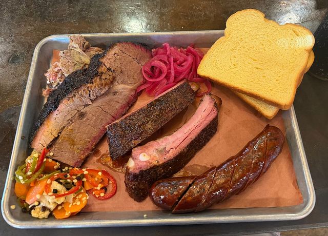 A barbecue tray of brisket, pork ribs, sausage, and pulled pork