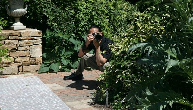 A wedding photographer shooting an outdoor ceremony